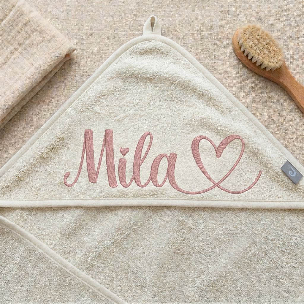 Ivory-Kapuzenhandtuch mit rosafarbener Mila-Herz-Stickerei als Flatlay