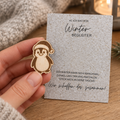 Taschenumarmung Pinguin aus Birkenholz in einer Hand – kleiner Mutmacher für die Tasche