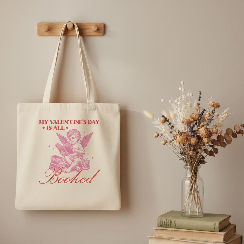 Stoffbeutel Valentinstag mit Engel-Motiv hängt an Wand neben Vintage-Büchern und Trockenblumen