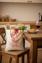 Baumwollbeutel Pasta is my love language gefüllt auf Holzstuhl mit frischen italienischen Zutaten