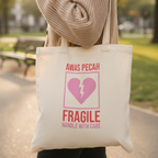 Frau trägt Statement Stoffbeutel Fragile in beiger Strickjacke im Park